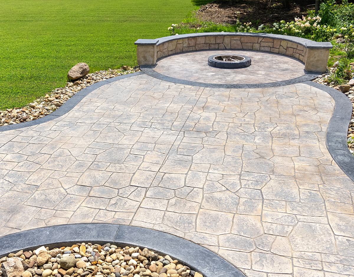 stamped concrete patio with fire pit and decorative wall